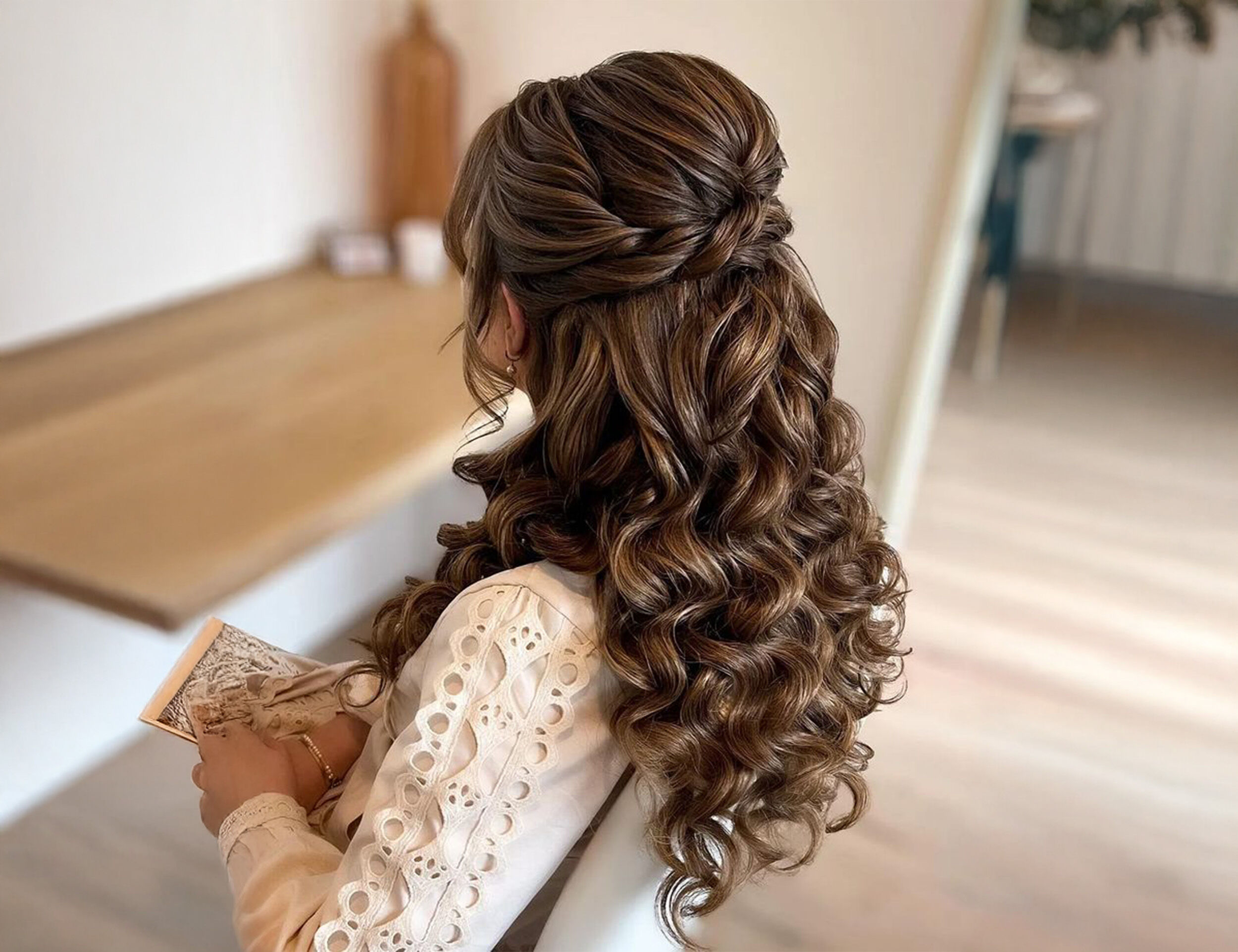 A beautifull women flaunting her curly hair styled by hair stylish for her wedding